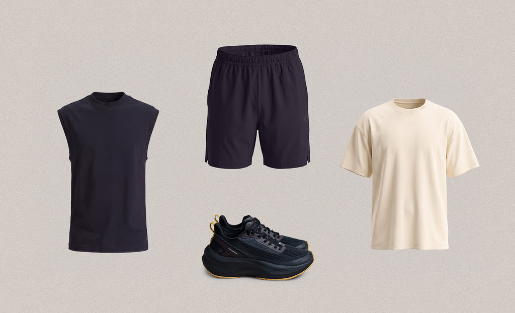 Four apparel items arranged on a light warm-gray background: a sleeveless dark navy top, dark navy shorts, a cream short-sleeve T-shirt, and dark navy athletic shoes with tan soles.